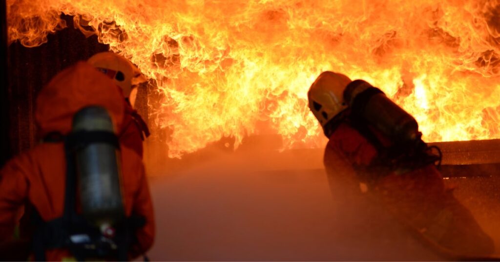 firefighters extinguishing a fire in a wall